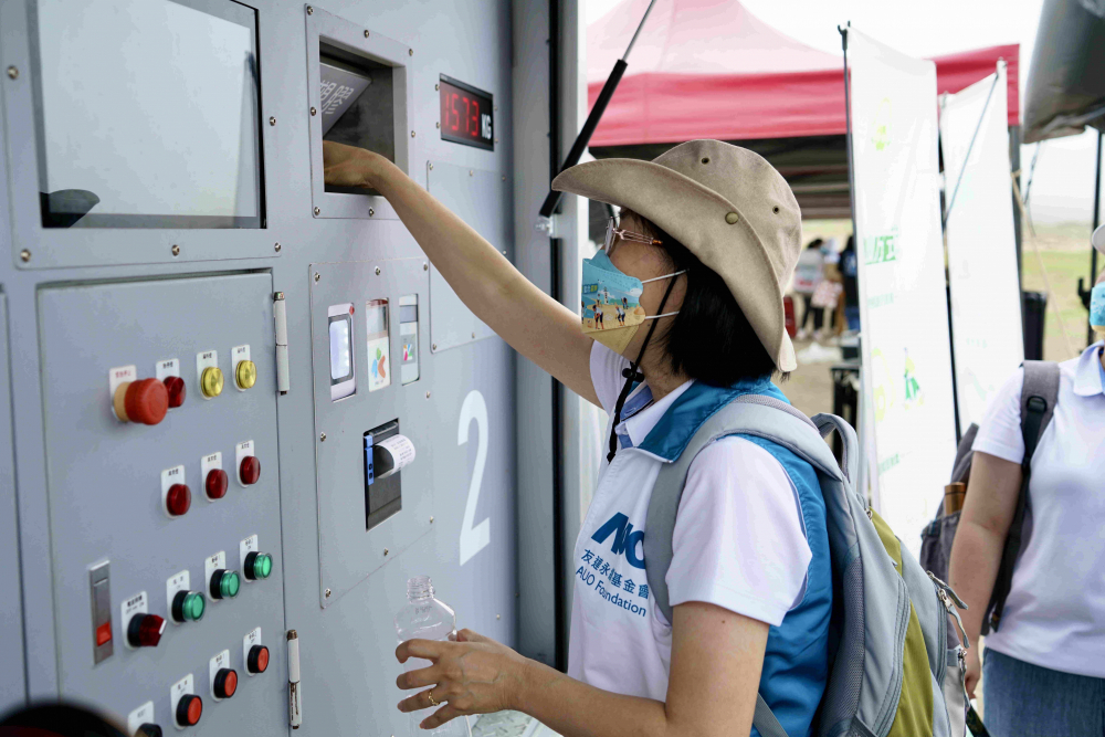 志工們將拾起的寶特瓶投入「好歸塑專車」，讓廢棄塑料空瓶可以直接粉碎、縮小體積，未來將可再製成購物袋、寶特衣、悠遊卡等生活用品